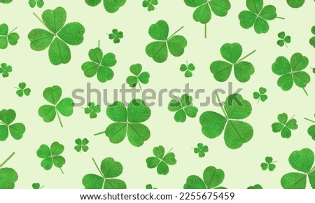 seamless pattern of three-leaf and four-leaf clover on a light green background