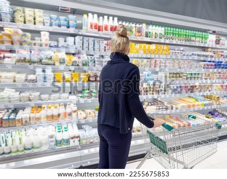 supermarket shopping,Woman choosing a dairy products at supermarket	 Royalty-Free Stock Photo #2255675853