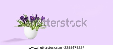 spring flowers in an egg, symbol for awakening of new life in springtime, easter greeting card banner with copy space