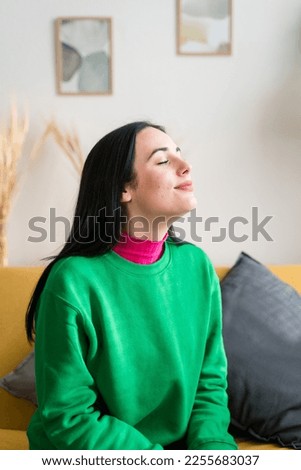 Young woman with closed eyes in living room