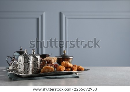 Tea, baklava dessert and Turkish delight served in vintage tea set on grey textured table, space for text