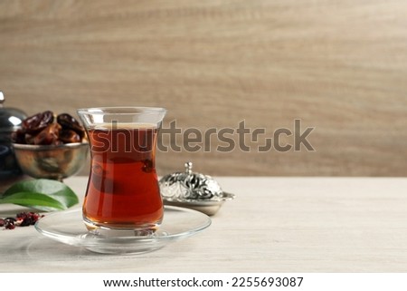 Tea in glass and vintage tea set on wooden table, space for text