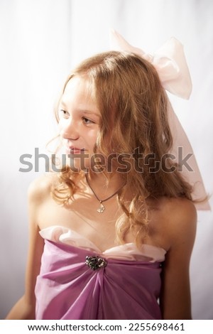 Portrait of cute kid girl posing in pink beautiful dress on a white background. Model in studio looking as gentle magic princess from fairy taly having photo shoot on white background