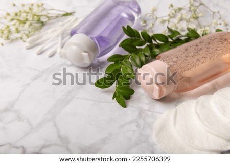 Micellar cleansing water and pads for removing makeup and cleansing the skin of sebium on a white marble table.Beauty concept. Flat lay.Copy the space text. Place to copy.