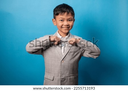 the studio shot isolated image of the boy wearing suit with the blue backdrop