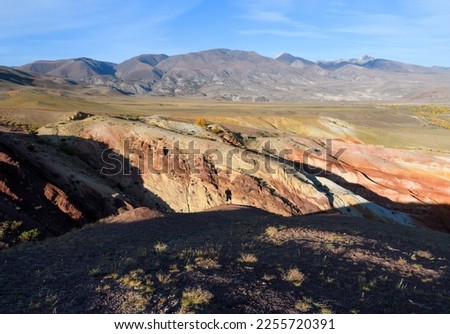 Photographer or tourist take picture of mars mountain valley landscape. Amazing Altai nature view of Kyzyl-Chin valley, mountain slopes. Concept of tourism and geology in Russia. Altai, Siberia.