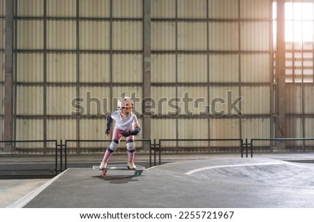 asian child skater or kid girl fun playing skateboard or ride surf skate on pump track and wave bank ramp in school skate park by extreme sports to wearing helmet elbow wrist knee support body safety Royalty-Free Stock Photo #2255721967