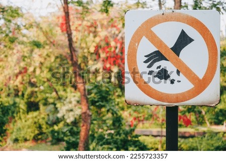 Do not litter sign and symbol on public park for warning litter waste is prohibit in area - No Garbage Sign in Green park background, Forbidden and STOP throw the trash - Environment Friendly concept