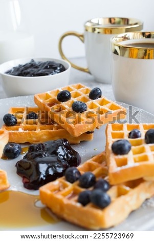 Homemade waffles with berries in a plate, on a gray background. Breakfast