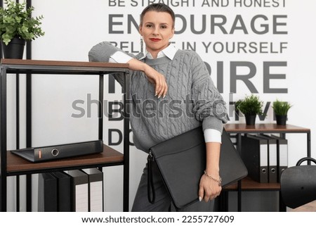 presentable young woman Businessman with a folder for documents on the background of the office