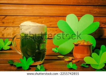 copy space. mug with green beer and wooden background with clover and gold coins.saint patrick's day