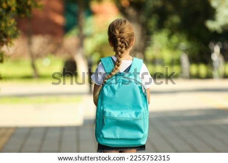 Little girl with turquoise backpack going to school outdoors, back view Royalty-Free Stock Photo #2255752315