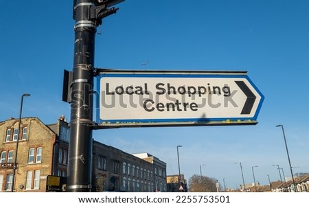 A street sign pointing to a local shopping centre.