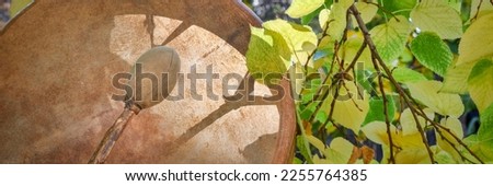 handmade, native American style, shaman frame drum with a beater against fall foliage Royalty-Free Stock Photo #2255764385