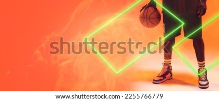 Low section of african american basketball player with ball by rectangles on orange background. Hand, leg, copy space, composite, illuminated, sport, competition, illustration, shape and smoke.
