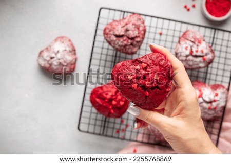 closeup heart shaped red velvet cupcake in female hand. Cooking with love concept. cropped image