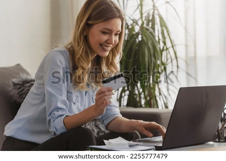 Young beautiful smiling woman paying making online payment with a credit card. Online banking.