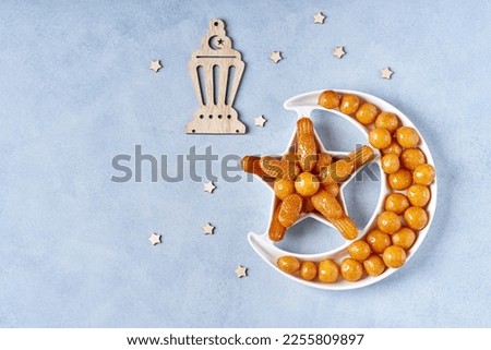 Ramadan kareem with fried sweets lokma, awameh arranged in shape of crescent moon. Iftar food concept. Top view, copy space	                                Royalty-Free Stock Photo #2255809897