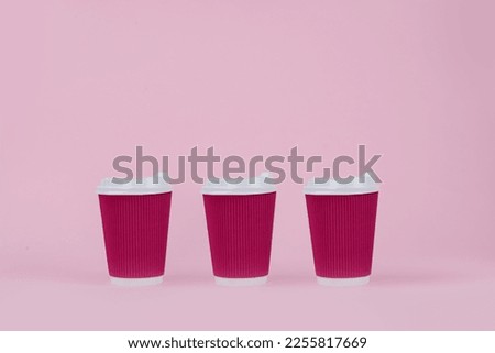 Magenta paper coffee cups on a pink background. Flat lay food and drink concept Close up