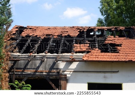 Burned house with holes in roof and building structure Royalty-Free Stock Photo #2255855543