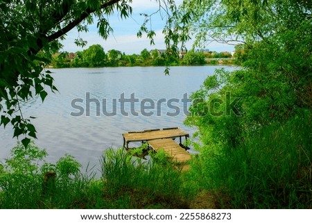 wooden pier on the lake.old wooden pier on the lake among trees and foliage.summer mood summer background