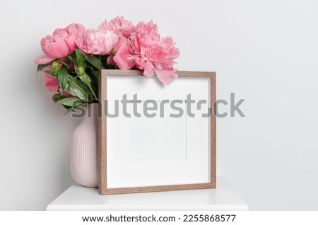 Square blank picture frame mockup with fresh peony flowers bouquet, copy space