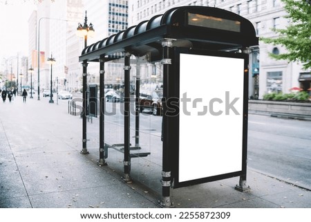 Contemporary white blank advertising sign of banner placed on empty public transport station on pavement near road of Chicago city Royalty-Free Stock Photo #2255872309