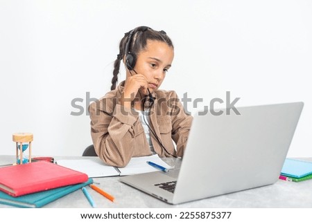 caucasian girl sitting at the desk and writing in a notebook and doing homework.