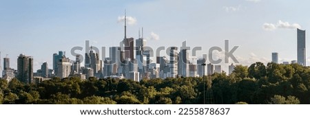 Toronto skyline at warm summer. Toronto, Ontario, Canada. Panoramic view of Toronto skyline near Ontario lake at sunset at scattered clouds.