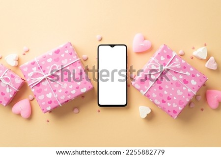 Valentine's Day concept. Top view photo of pink gift boxes smartphone heart shaped marshmallow candles and sprinkles on isolated beige background with copyspace