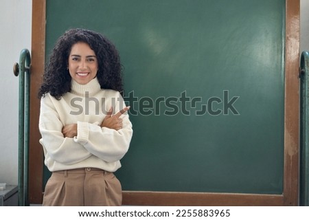 Young happy woman school professional teacher, female coach leader pointing at empty blank mock up chalkboard in classroom presenting showing business training course virtual education classes ads. Royalty-Free Stock Photo #2255883965
