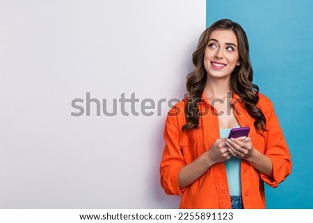 Photo portrait of young attractive woman hold device ecommerce announcement dressed stylish orange outfit isolated on blue color background