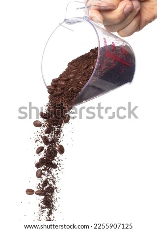 Coffee powder mix bean fall down pour in measured cup, Coffee crushed mix seed float explode, abstract cloud fly. Coffee dust powder bean splash throwing in Air. White background Isolated high speed