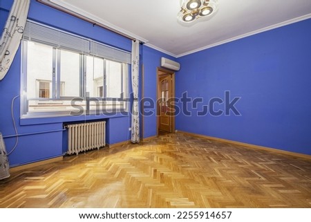 Empty living room with dark blue painted walls, French oak parquet floors and aluminum sliding window panes
