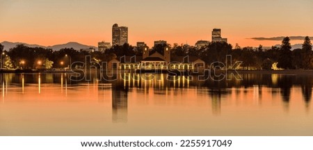 City Park at Dusk - A colorful Autumn dusk view of Ferril Lake in Denver City Park, with front range mountains and landmark skyscrapers in background, at east-side of Downtown Denver, Colorado, USA.