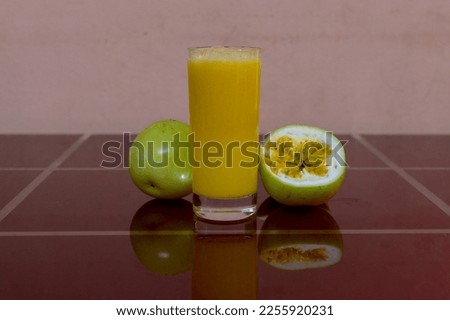 Closeup glass of passionfruit juice with passion fruit half slice, Healthy drinks concept.