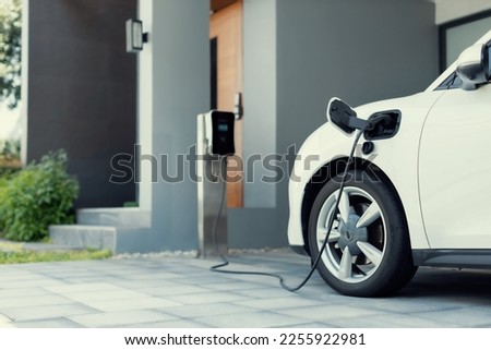 Progressive concept of EV car and home charging station powered by sustainable and clean energy with zero CO2 emission for green environmental. Charging point at residential area for electric vehicle. Royalty-Free Stock Photo #2255922981