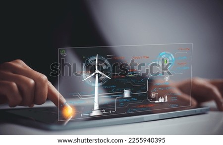 Engineer using tablet to adjust power of wind turbines to power industrial plant. Concept of renewable and clean energy in the manufacturing industry. Royalty-Free Stock Photo #2255940395