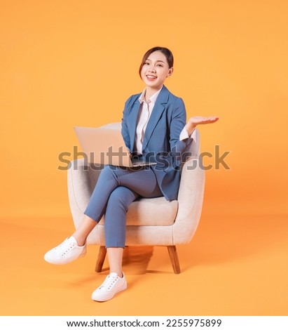 Photo of young Asian businesswoman sitting on armchair