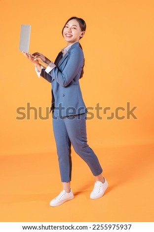 Full length image of young Asian business woman on background