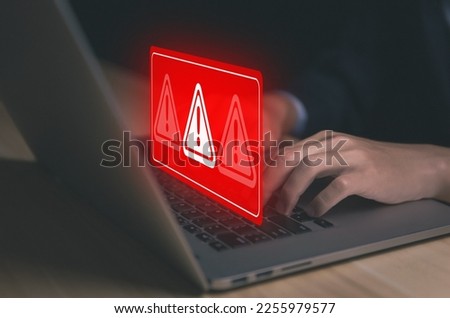Businessman using laptop showing warning triangle and exclamation sign icon Warning of dangerous problems Server error. Virus. Maintenance concept. caution internet technology network security Royalty-Free Stock Photo #2255979577