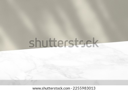 White Diagonal Marble Table with Beige Stucco Wall Texture Background with Light Beam and Shadow, Suitable for Product Presentation Backdrop, Display, and Mock up. Royalty-Free Stock Photo #2255983013
