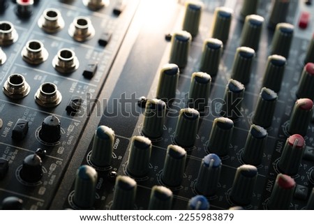 Knobs and switches of audio mixer or recording console. Recording background.  shallow depth of field. Incoming light.