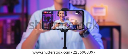 Vlogger live streaming podcast review on social media, Young Asian woman use microphones wear headphones with smartphone record video. Content creator concept. Royalty-Free Stock Photo #2255988097