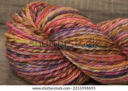 Closeup of colourful handspun and handdyed merino sheep wool, spun on a spinning wheel