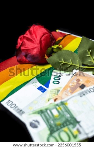 Red rose on money and a lgbtq flag on black background
