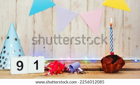 Festive Happy birthday background with number or digit  91. Postcard with a muffin and burning candles. Festive copy space background.