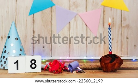 Festive Happy birthday background with number or digit  18. Postcard with a muffin and burning candles. Festive copy space background.