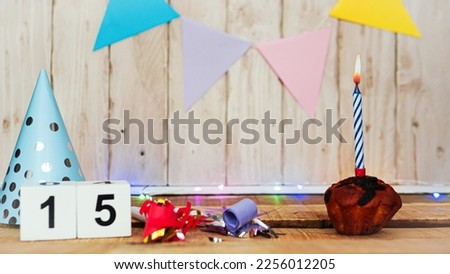 Festive Happy birthday background with number or digit  15. Postcard with a muffin and burning candles. Festive copy space background.