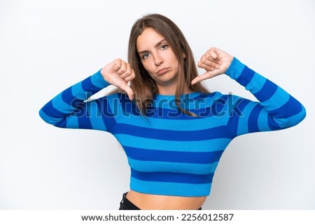 Young caucasian woman isolated on white background showing thumb down with two hands